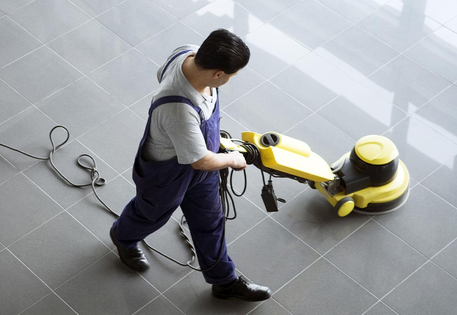 Custodian spot-cleaning smooth tile floor.