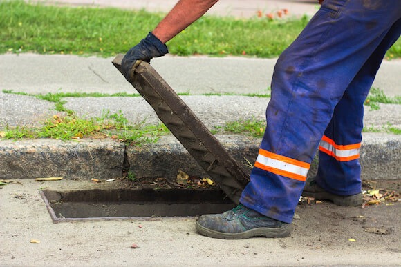landscape-rain-water-runoff-reclamation-reuse-commercial-property-maintenance-california california water board inspector checks storm drain for code violations