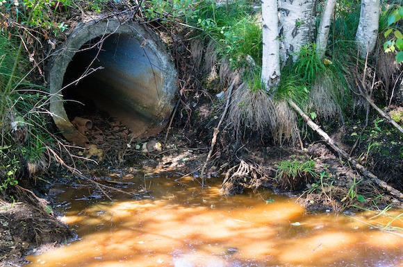 storm drain pollution contaminants flow into natural water stream