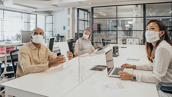 workers return to office with dividers partitions safe shared space