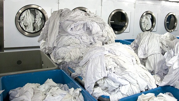 senior-living-industrial-laundry-facility-hotel-hospitality-multifamily-high-rise linen chute to laundry hopper washing machine room in california