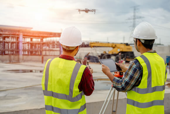 Construction Professionals Using Drone and Tablet for Property Analysis