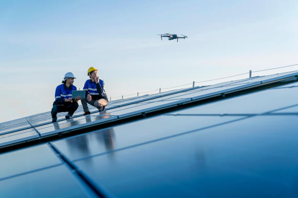 Solar Technicians Operating Overhead Drone