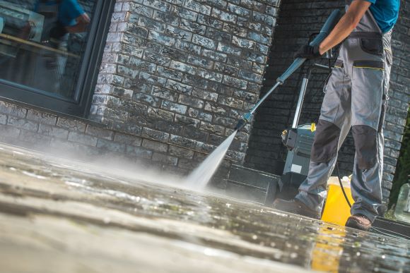 Power Wash Technician Cleaning Commercial Pavement