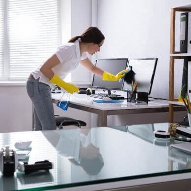 Sanitation Professional Wiping Down Office Desk