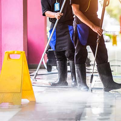 CAM employees pressure washing sidewalk