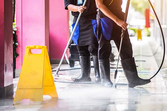CAM employees pressure washing sidewalk